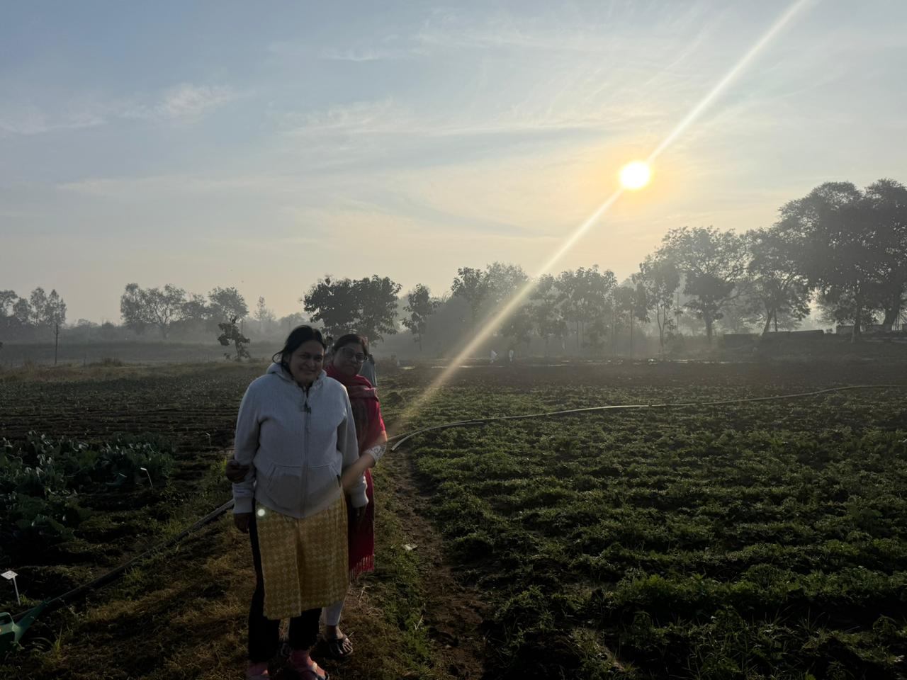 Two faculty members at sunrise on the research field